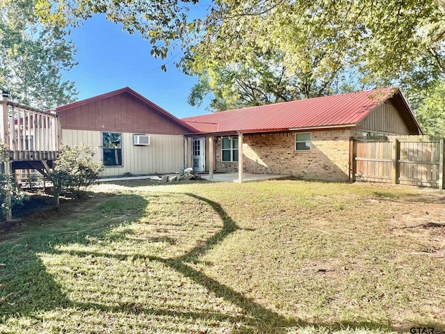 rear view of house with a patio area, a lawn, and a wooden deck