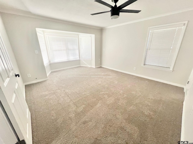 interior space with carpet flooring, ceiling fan, and crown molding