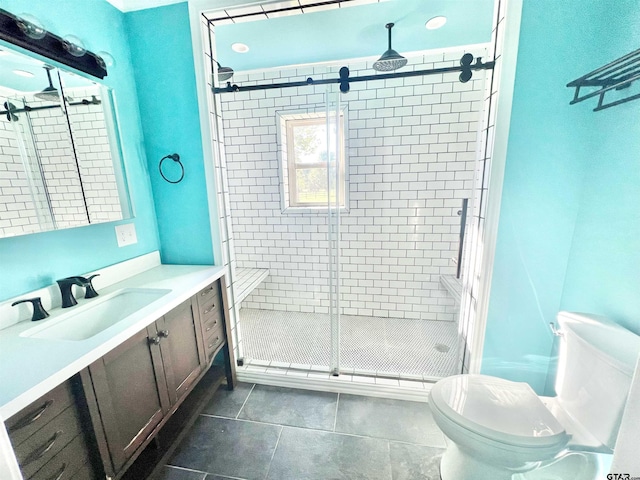 bathroom with vanity, a shower with door, tile patterned flooring, and toilet