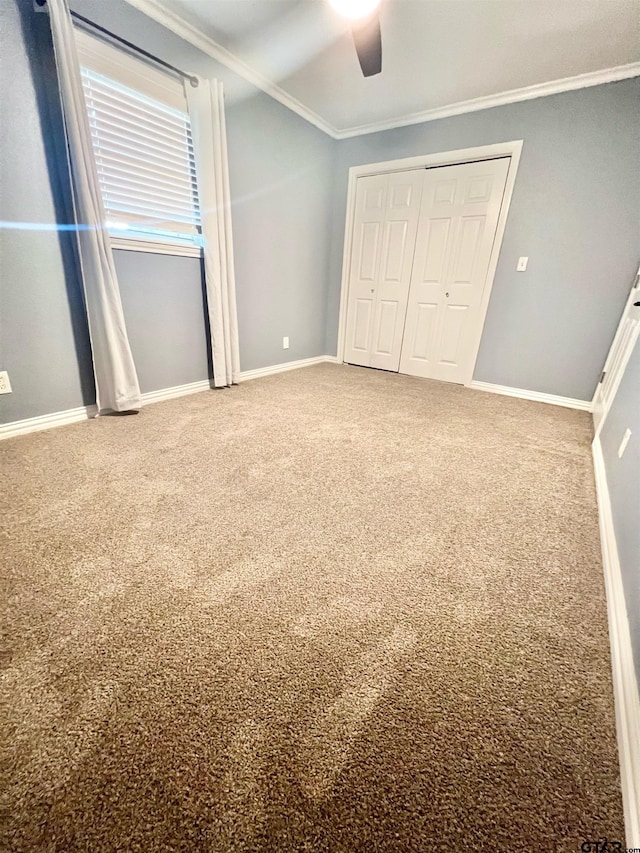 unfurnished bedroom featuring ceiling fan, carpet flooring, and ornamental molding