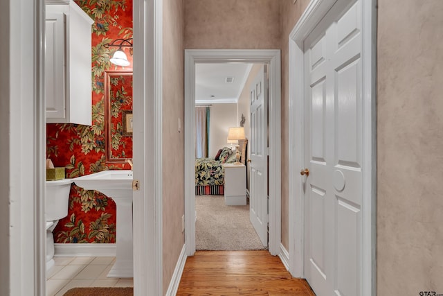 1014 Lovers Ln, Longview, TX 75604 - corridor featuring wallpapered walls, baseboards, ornamental molding, and light wood-style flooring