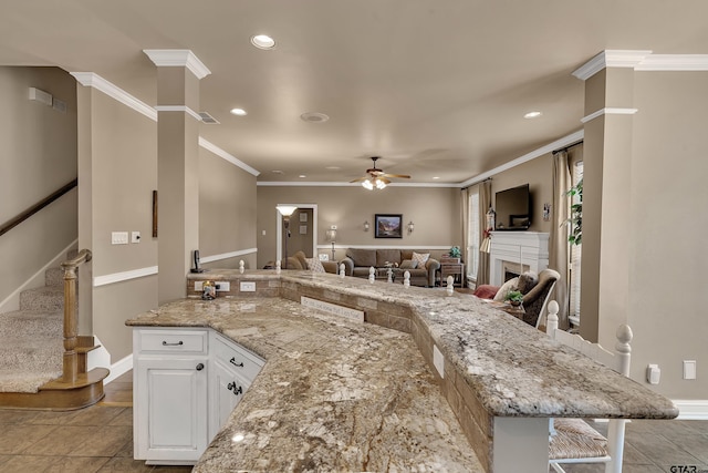 1014 Lovers Ln, Longview, TX 75604 - kitchen with ceiling fan, open floor plan, recessed lighting, white cabinetry, and light stone countertops