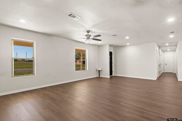 unfurnished room with dark hardwood / wood-style flooring, plenty of natural light, and ceiling fan