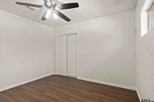 unfurnished bedroom featuring ceiling fan, dark hardwood / wood-style floors, and a closet