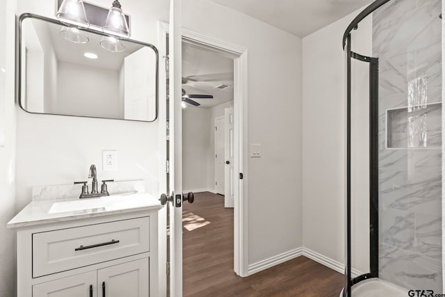 bathroom featuring wood-type flooring, vanity, an enclosed shower, and ceiling fan