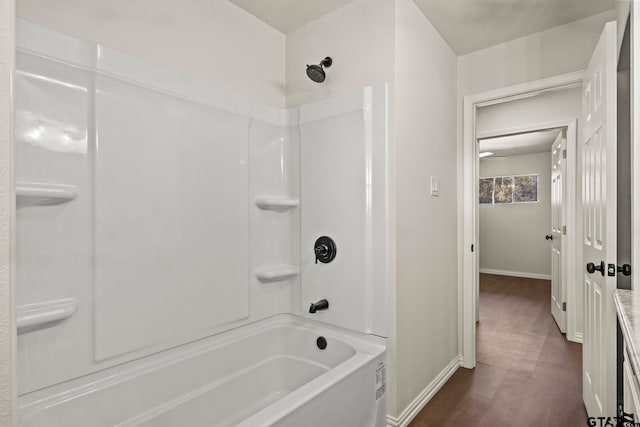 bathroom with wood-type flooring and tub / shower combination