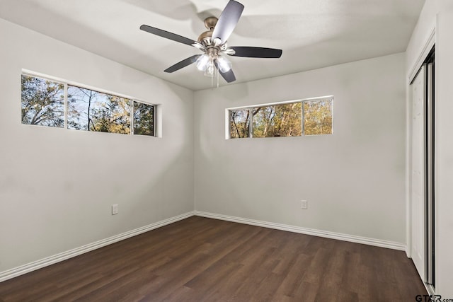 unfurnished bedroom featuring ceiling fan, dark hardwood / wood-style flooring, and a closet