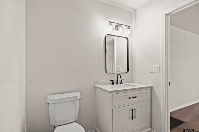 bathroom featuring hardwood / wood-style floors, vanity, and toilet