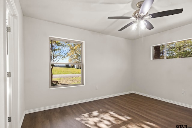 unfurnished room featuring ceiling fan, a healthy amount of sunlight, and dark hardwood / wood-style floors