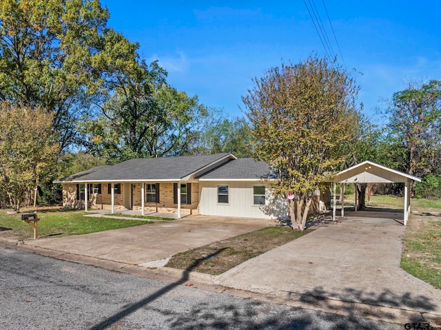 view of front facade with a front yard, a carport, and covered porch