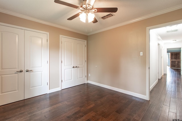 17893 Slack Rd, Whitehouse, TX 75791 - unfurnished bedroom with dark wood-style flooring, multiple closets, ornamental molding, and ceiling fan