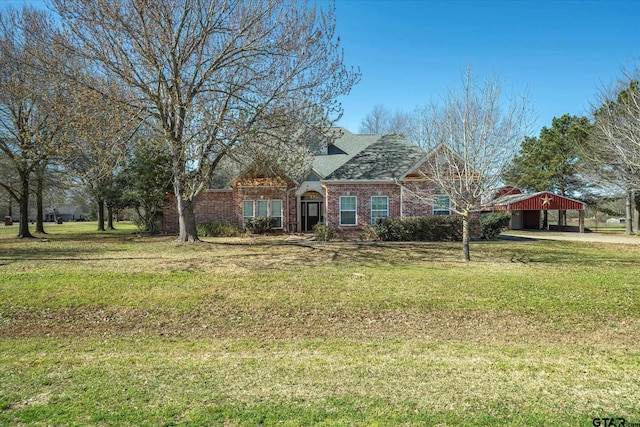 view of front of house featuring a front lawn, brick siding, and a detached carport