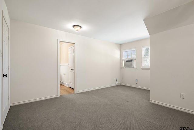 carpeted spare room featuring cooling unit and baseboards