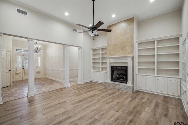 unfurnished living room featuring wood finished floors, visible vents, ornamental molding, a fireplace, and ceiling fan