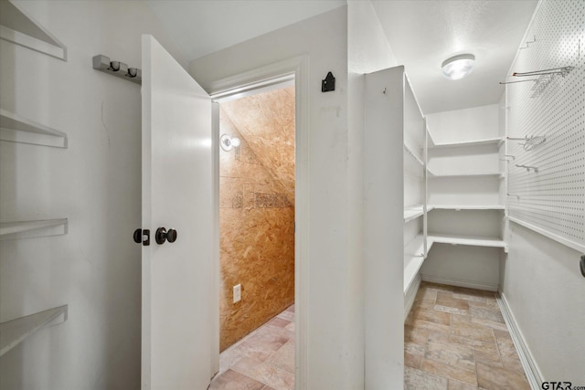 bathroom with baseboards and stone finish floor
