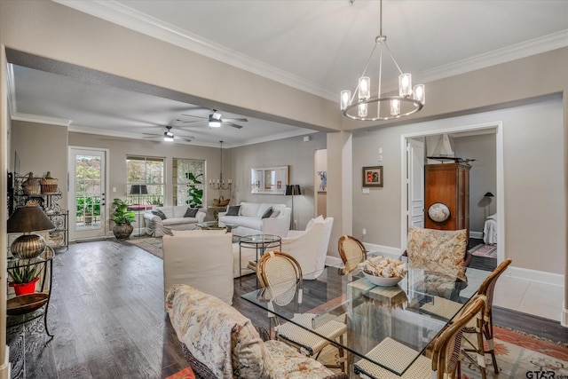 dining area with ceiling fan with notable chandelier, crown molding, and dark wood-type flooring