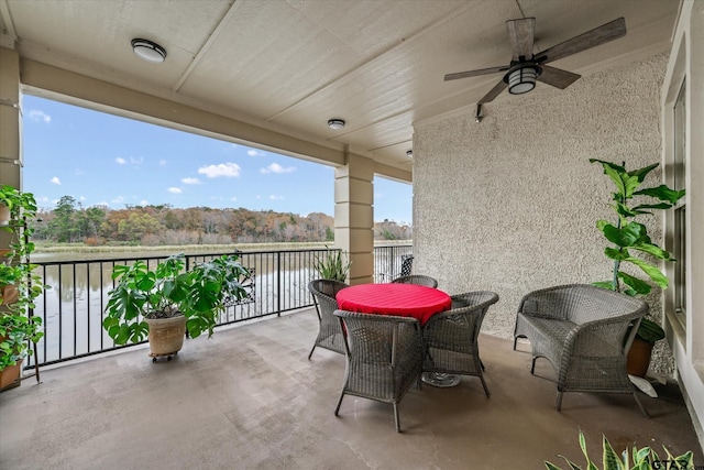 balcony with ceiling fan and a water view