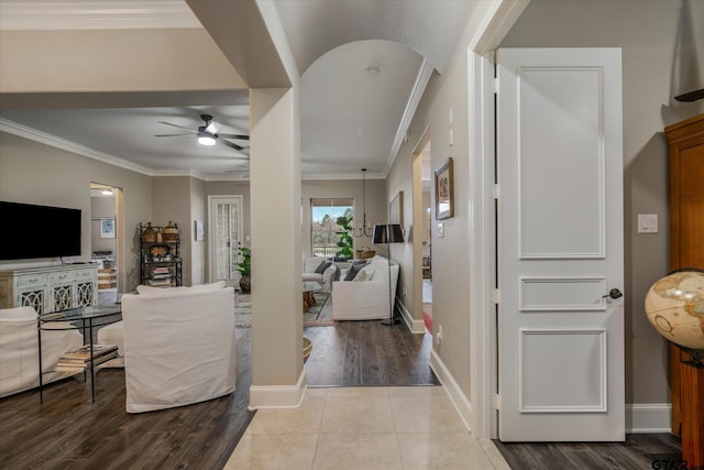 foyer featuring ceiling fan, crown molding, and light wood-type flooring