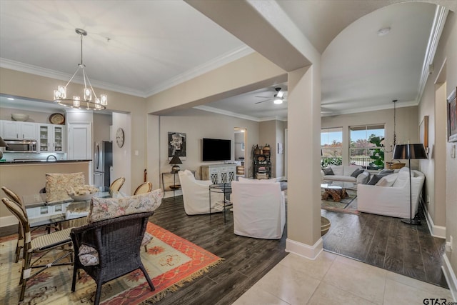 living room featuring ceiling fan with notable chandelier, crown molding, and light hardwood / wood-style flooring