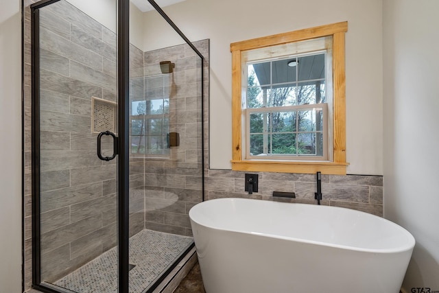 9089 Raspberry Ave, Frankston, TX 75763 - bathroom featuring a stall shower, a freestanding bath, and tile walls