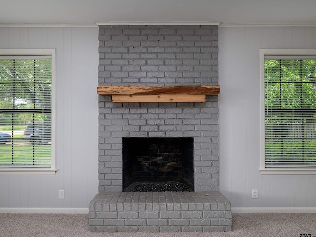 interior details with carpet floors, baseboards, and a brick fireplace