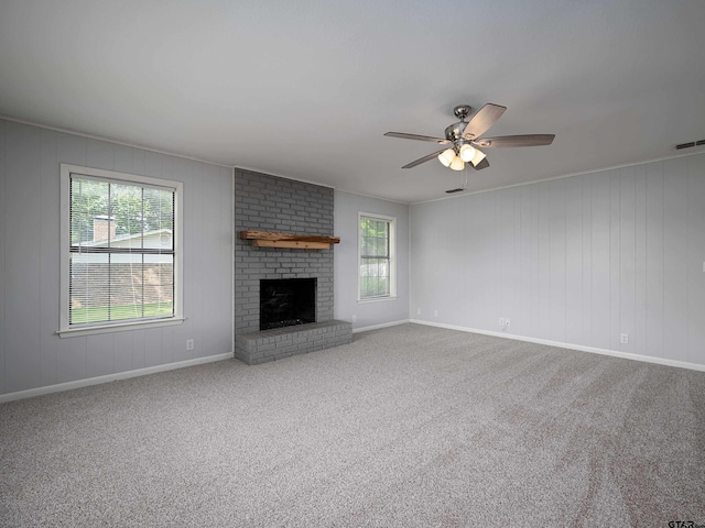 unfurnished living room with carpet floors, a ceiling fan, visible vents, and a wealth of natural light