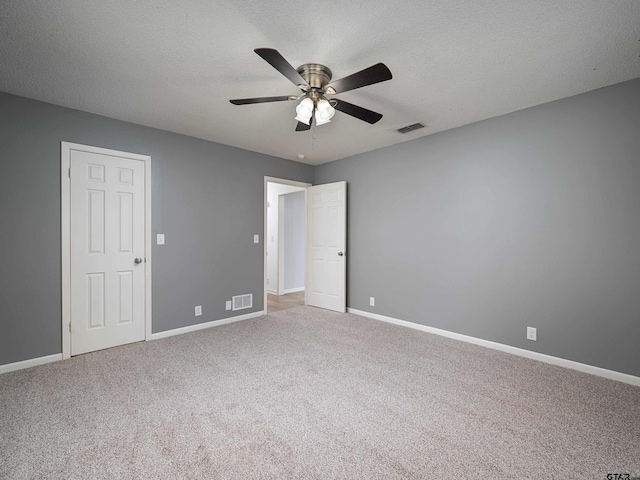 unfurnished bedroom featuring carpet floors, baseboards, a ceiling fan, and visible vents