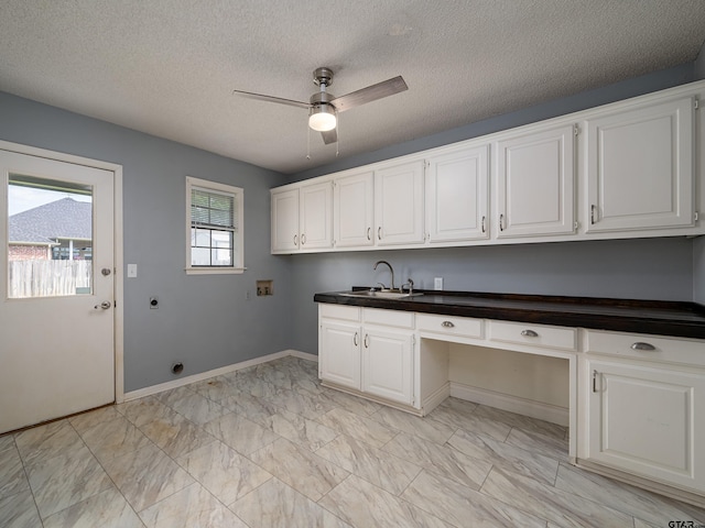 laundry area featuring cabinet space, ceiling fan, a sink, hookup for a washing machine, and baseboards