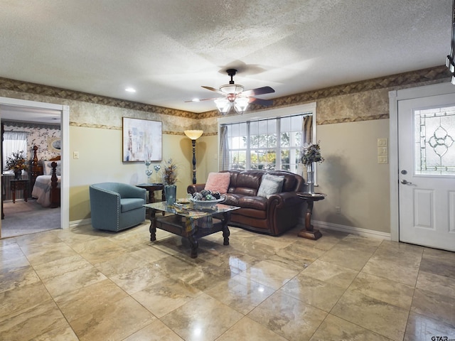 living room with a textured ceiling and ceiling fan