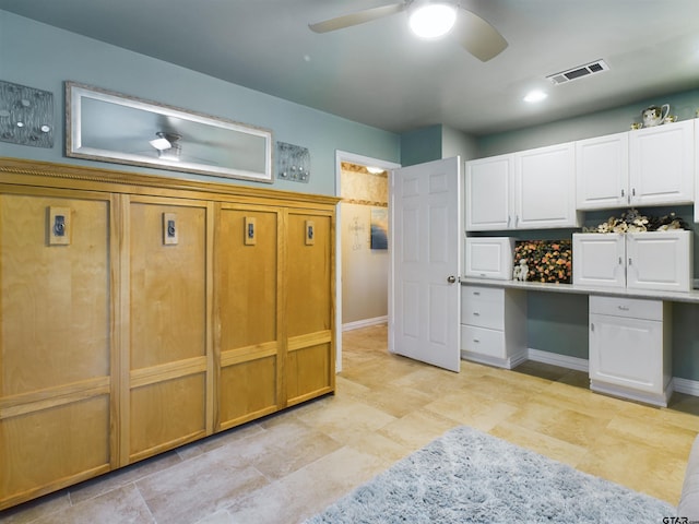 kitchen featuring backsplash, white cabinetry, and built in desk