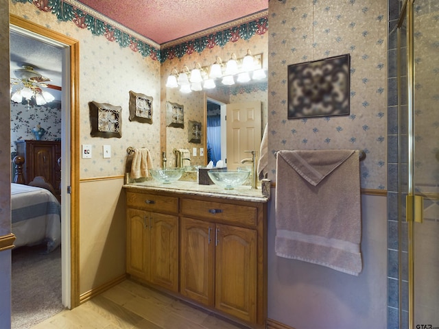 bathroom with vanity, a textured ceiling, an enclosed shower, and ceiling fan