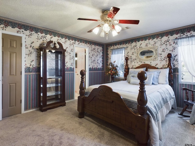 bedroom with carpet flooring, ceiling fan, and a textured ceiling