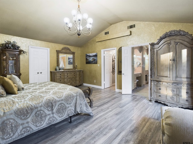 bedroom with lofted ceiling, ensuite bath, a notable chandelier, wood-type flooring, and a closet