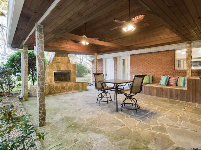 view of patio with ceiling fan and an outdoor stone fireplace