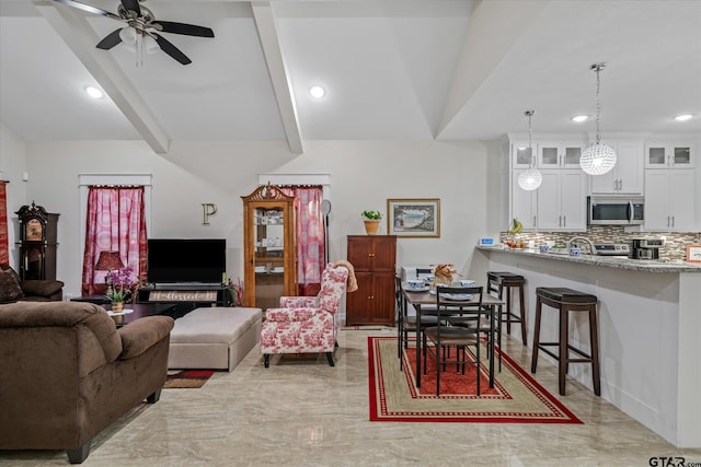 living room with ceiling fan and beam ceiling