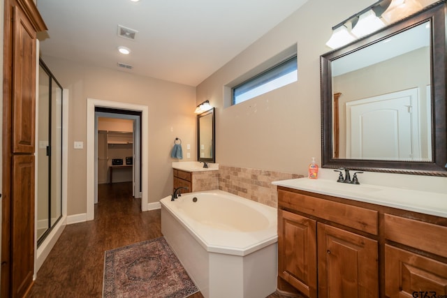 full bath with a stall shower, visible vents, a bath, and wood finished floors