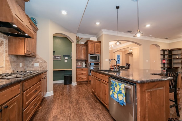 kitchen with dark wood-style floors, brown cabinets, a kitchen breakfast bar, stainless steel appliances, and a sink