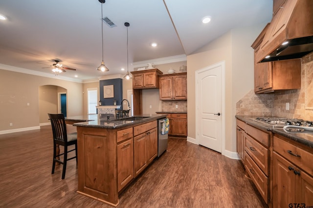 kitchen with a sink, a kitchen breakfast bar, range hood, brown cabinets, and dishwasher