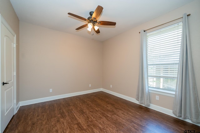 unfurnished room featuring baseboards, dark wood finished floors, and a ceiling fan