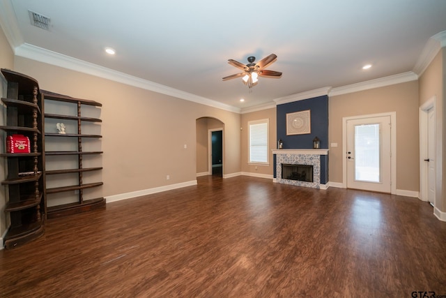 unfurnished living room featuring arched walkways, visible vents, plenty of natural light, and wood finished floors