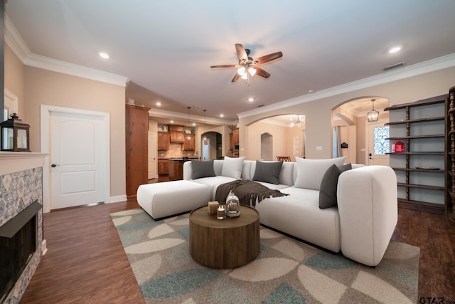 living area featuring arched walkways, a tiled fireplace, visible vents, and recessed lighting