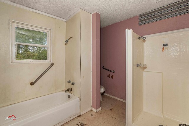 bathroom with washtub / shower combination, a textured ceiling, and toilet