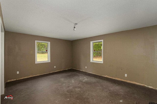 unfurnished room featuring a textured ceiling