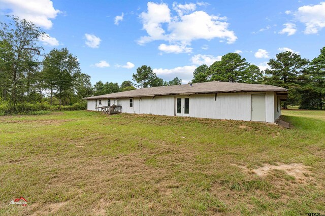 rear view of property featuring a yard