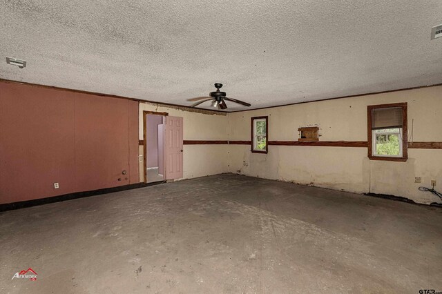 empty room featuring concrete flooring, ceiling fan, and a textured ceiling