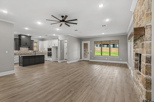 unfurnished living room featuring light hardwood / wood-style flooring and crown molding