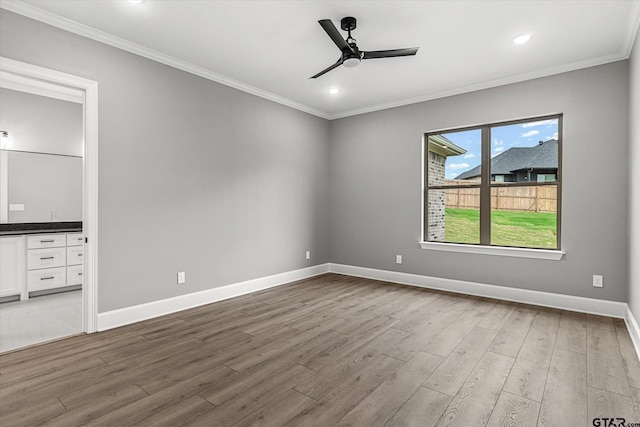 unfurnished bedroom featuring ceiling fan, wood-type flooring, ornamental molding, and ensuite bath