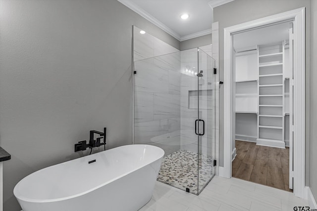 bathroom with hardwood / wood-style floors, ornamental molding, and shower with separate bathtub