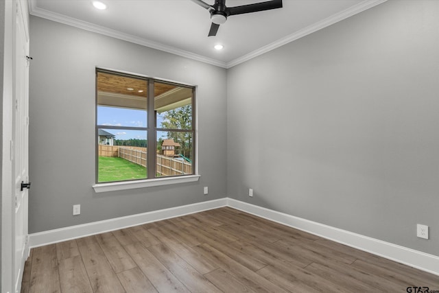 empty room featuring ceiling fan, wood-type flooring, and ornamental molding