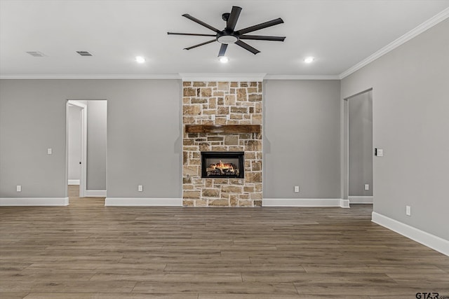 unfurnished living room featuring a stone fireplace, ceiling fan, ornamental molding, and hardwood / wood-style flooring